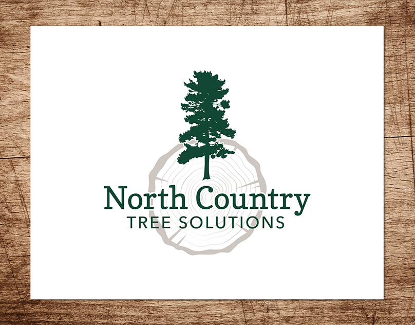 Logo for North Country Tree Solutions featuring a pine tree and tree ring